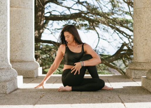 woman in black tank top and black leggings sitting on floor